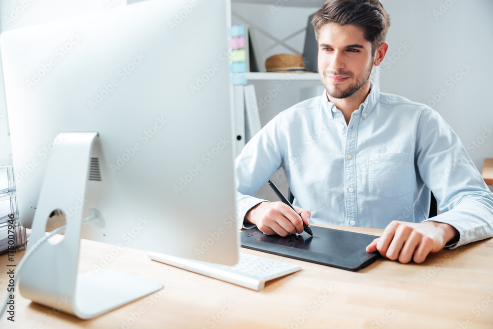 Man designer working using computer and graphic tablet at workplace
