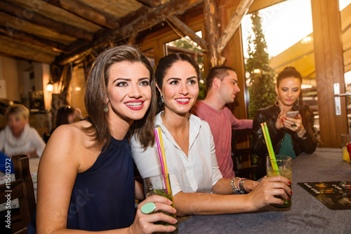 Young beautiful women with cocktails in bar or club