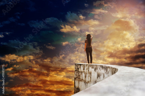 Women on dead end way high up on vast sky photo