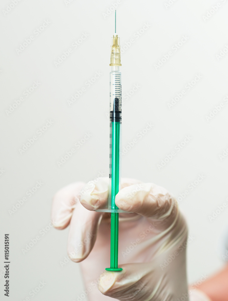 Doctor's hand holding syringe with injection. Doctor's hand holding syringe with injection.