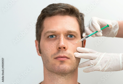Handsome man is getting injection. Concept of aesthetic beauty. Place for your text.