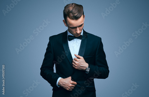 Handsome young man in a tuxedo looking at the camera. Fashionable Clothing. Clothing for the festive evening