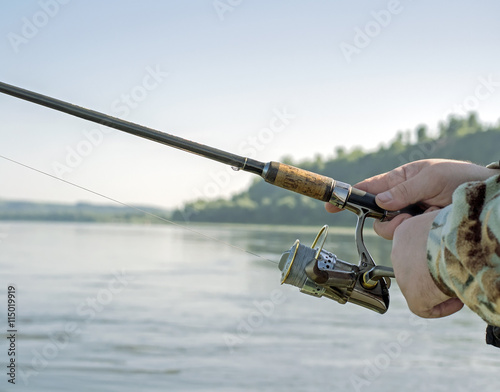 A fisherman catches a fish on spinning