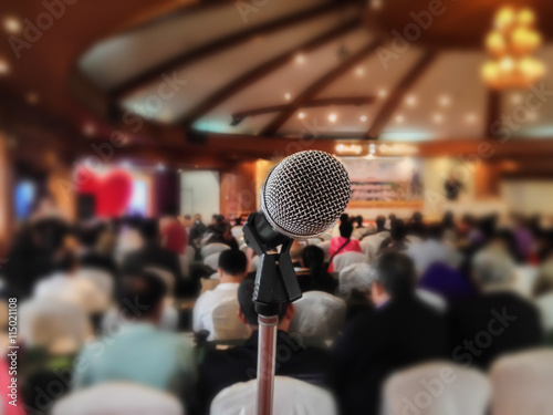 Microphone set up on blurred people in seminar event hall