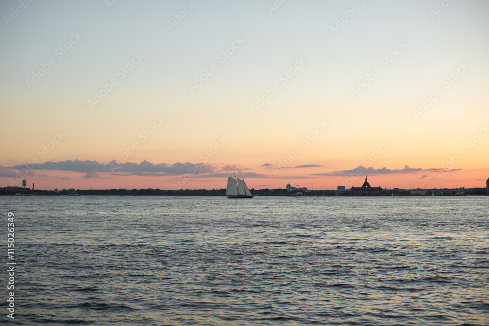 Sunset over Hudson river whit small boat 