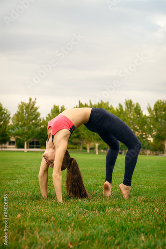 Pretty woman doing yoga exercises in the park