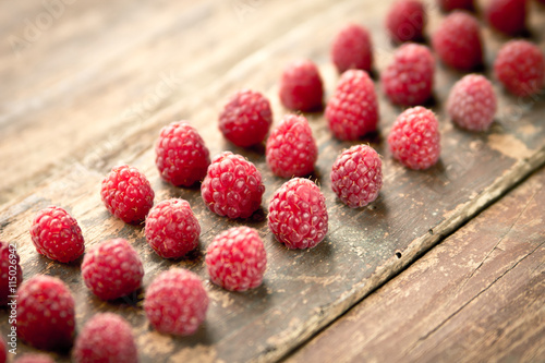 Ripe sweet raspberries on wooden background