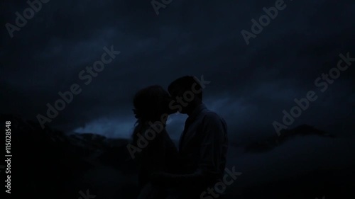 Silhouettes of kissing couple in the twilight.
