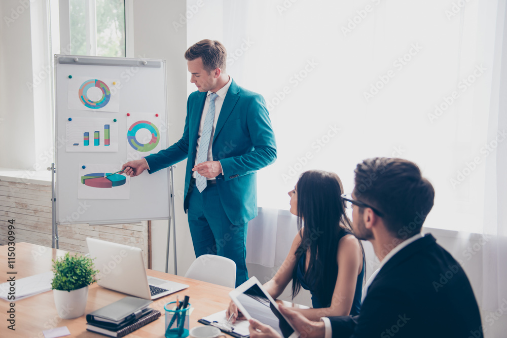 Obraz premium Young businessman making presentation and showing diagrama on wh