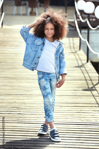 Afro American little girl wearing denim clothes outdoors. Fashion kid concept