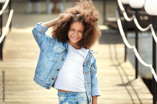 Afro American little girl wearing denim clothes outdoors. Fashion kid concept