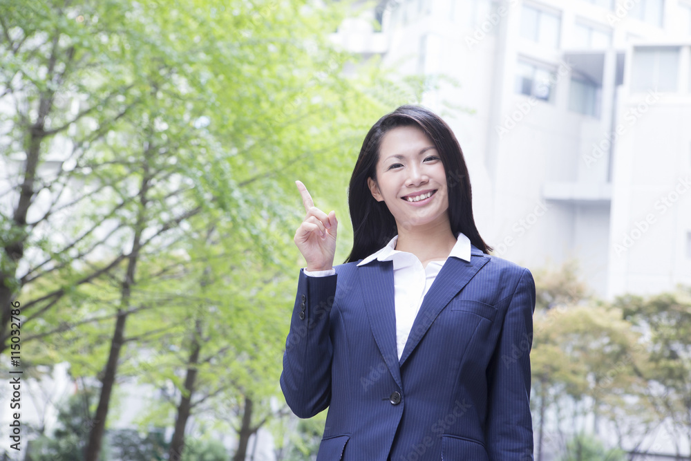 指さしする若い女性　屋外ビジネスイメージ