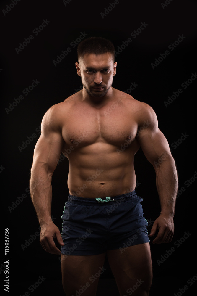 handsome muscular bodybuilder posing on a black background handsome muscular bodybuilder posing on a black background