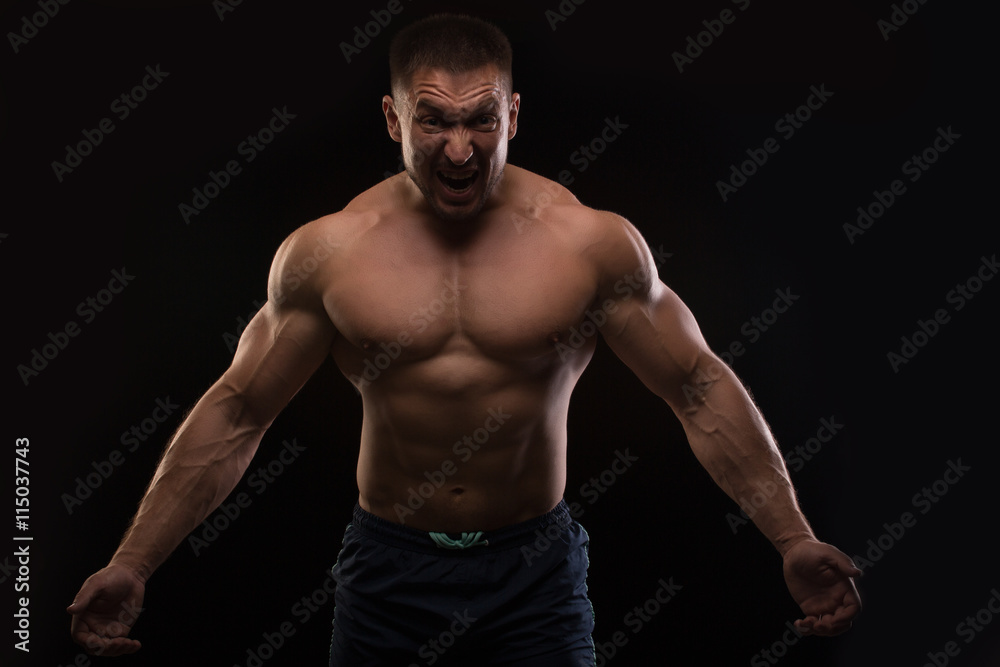 handsome muscular bodybuilder posing on a black background handsome muscular bodybuilder posing on a black background