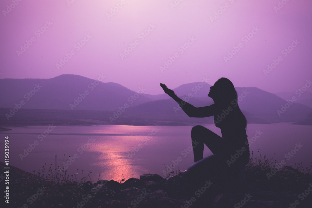 Silhouette of woman praying