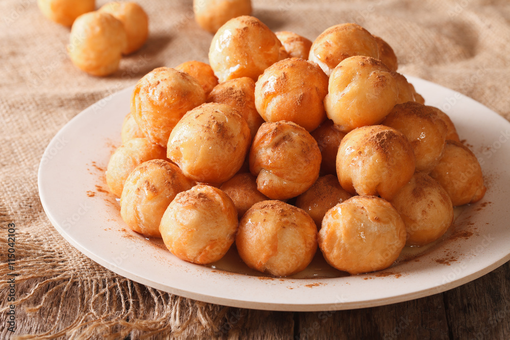 Turkish lokma donuts with honey and cinnamon close-up. horizontal
Turkish lokma donuts with honey and cinnamon close-up. horizontal