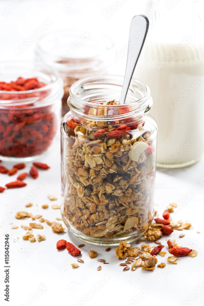 Healthy granola with goji berries in a glass jar, closeup