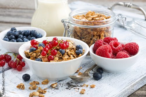 muesli and fresh berries on white wooden table