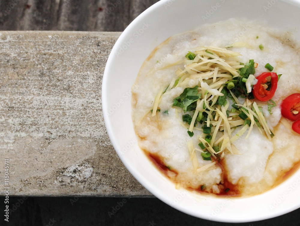 asian food - a bowl of congee with minced pork on grunge background