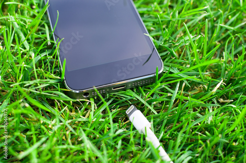 Phone detail with cable on grass