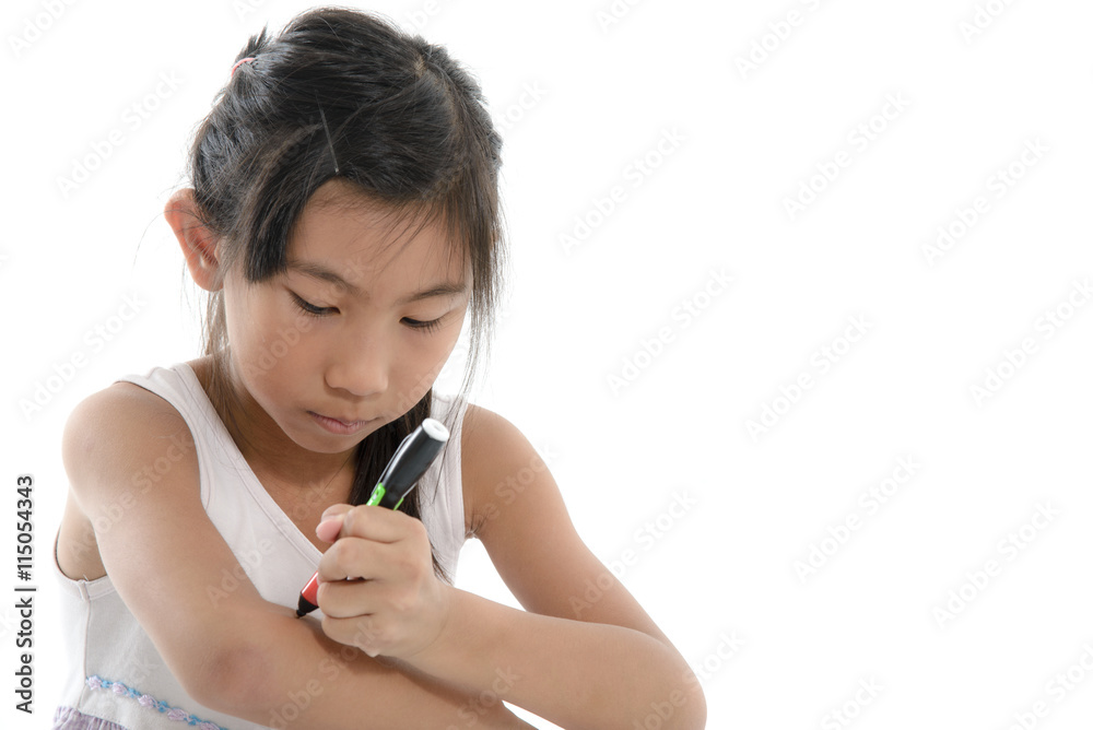 Asian child writing something on her arm on white. Asian child writing something on her arm on white.
