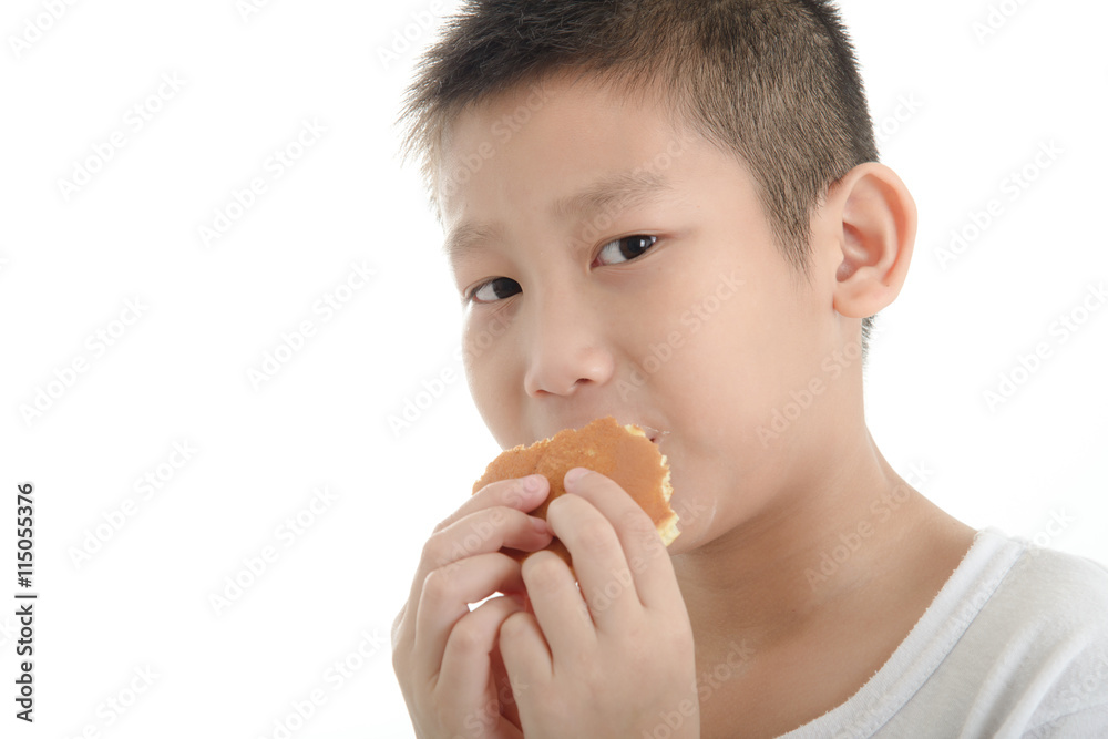 Asian boy eating dorayaki bun on white background. Asian boy eating dorayaki bun on white background.