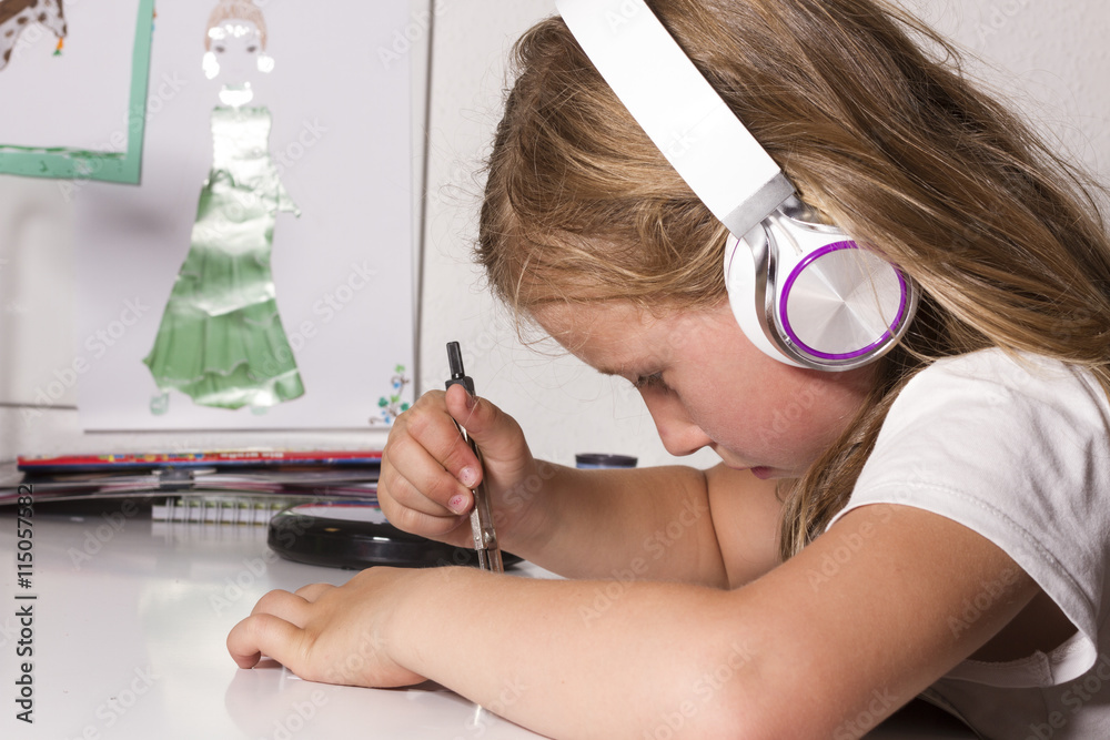 Naklejka premium Kind hört Musik mit Kopfhörern und malt mit Zirkel