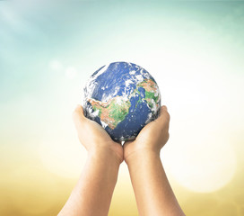 Hands holding earth globe on blurred background for environment and global conservation concept