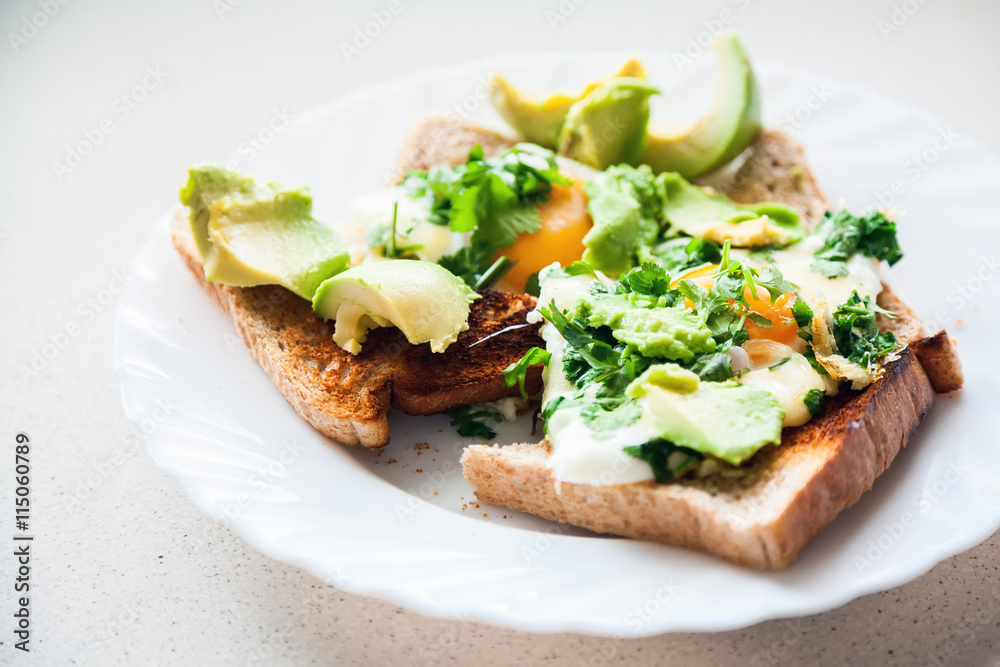 two eggs on toasts with avocado