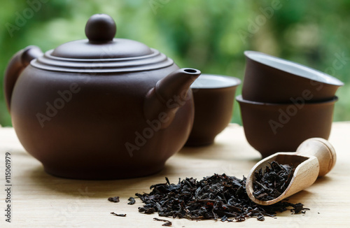 Black tea, teapot and cups on the table
