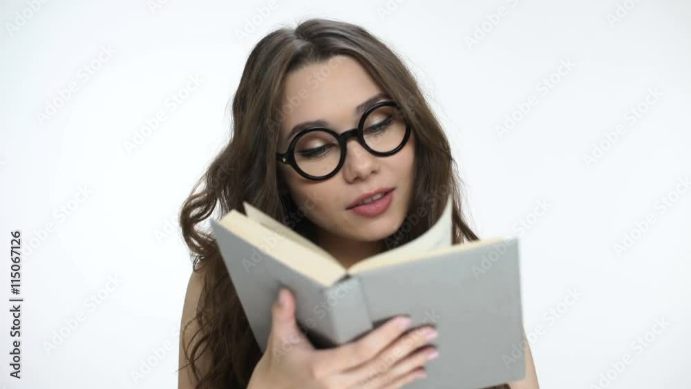 Beautiful young brunette girl in nerd glasses reading a book Beautiful young brunette girl in nerd glasses reading a book