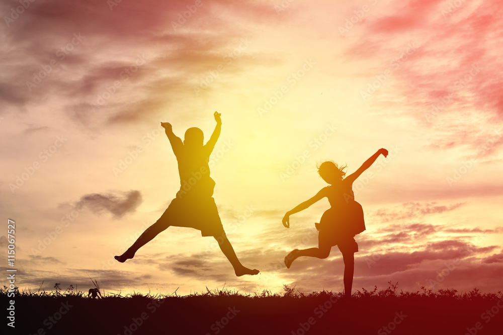 Silhouette children jumping on sunset