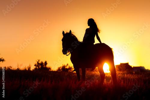 Beautiful silhuette of girl and horse at sunset 