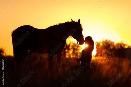 Beautiful silhuette of girl and horse at sunset 