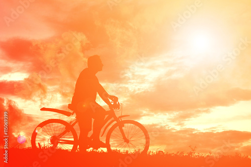 Fototapeta Naklejka Na Ścianę i Meble -  Silhouette  man with bicycle at sunset. relax time