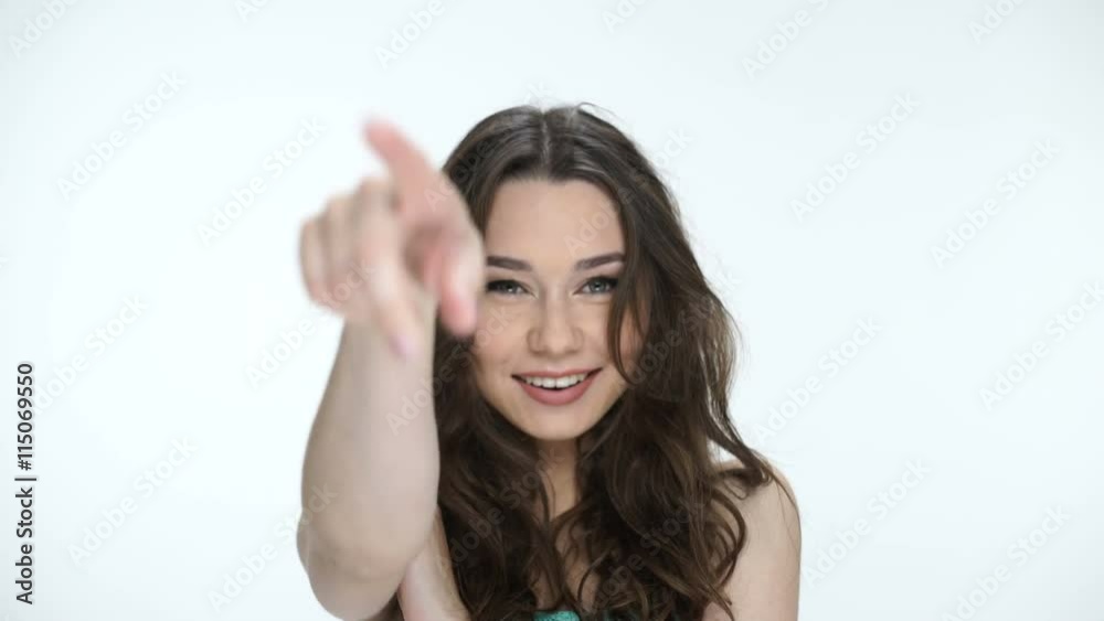 Portrait of a pretty brunette girl pointing finger forward isolated on a white background Portrait of a pretty brunette girl pointing finger forward isolated on a white background