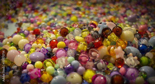 A cross lays in the colorful beads.