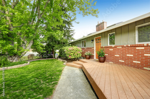 American home with patio area, also grass filled lawn.