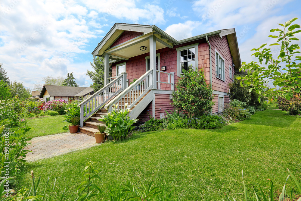 Big farmhouse with beautiful flowerbed, concrete walkway
