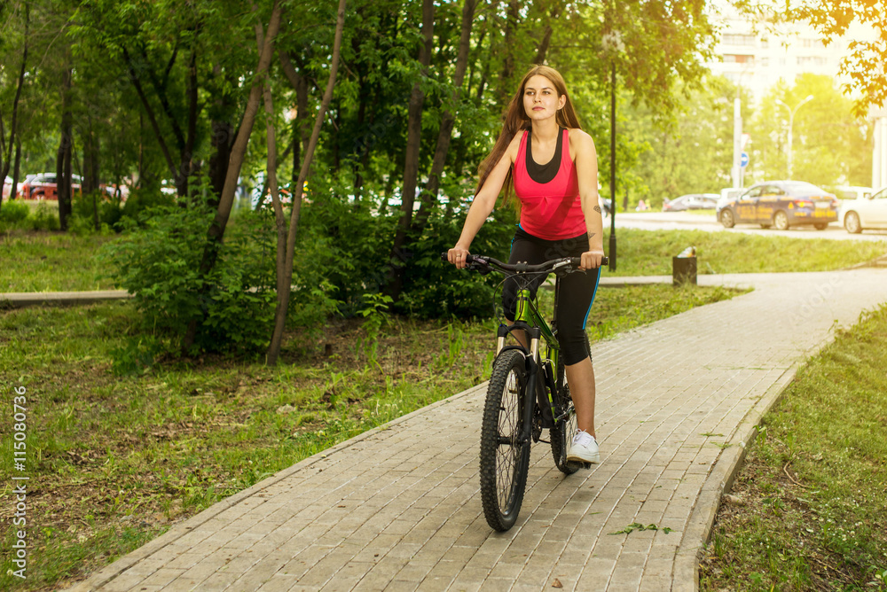 Happy girl cyclist riding on a mountain bike outside Happy girl cyclist riding on a mountain bike outside
