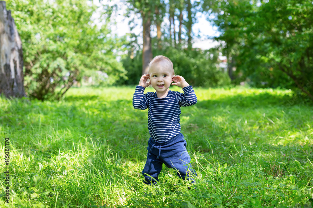 pretty baby boy standing in high grass in sun light pretty baby boy standing in high grass in sun light