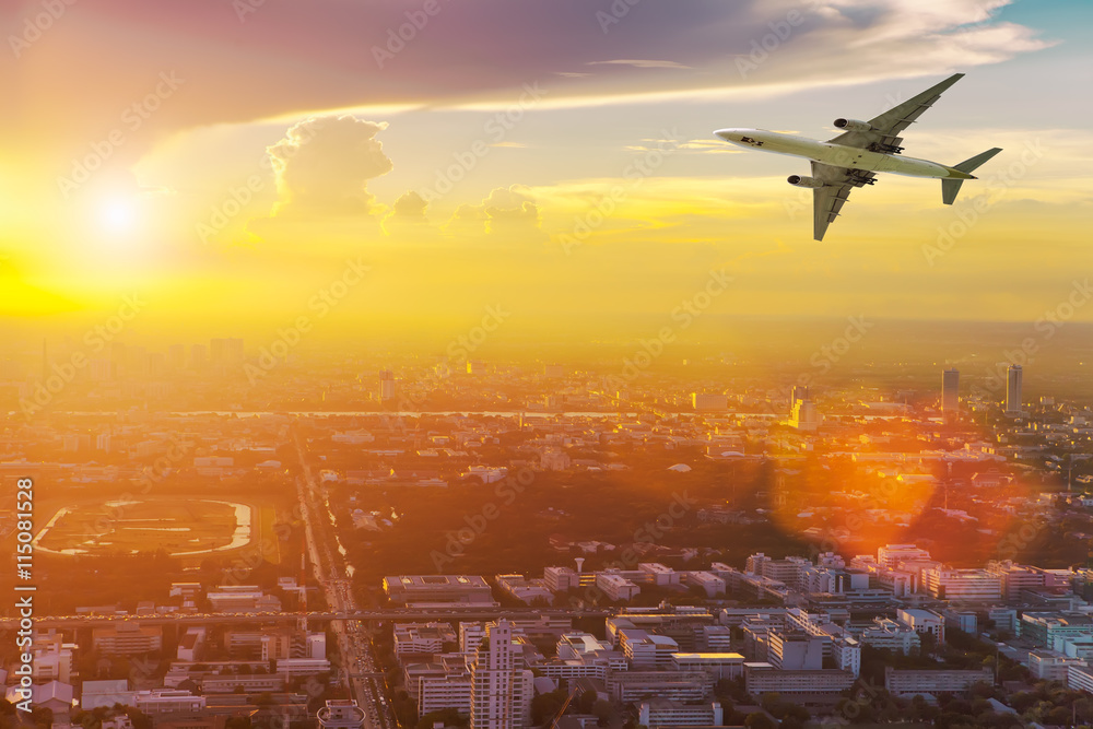 Airplane in the sky above city at sunset. Amazing trip. Travel c Airplane in the sky above city at sunset. Amazing trip. Travel c