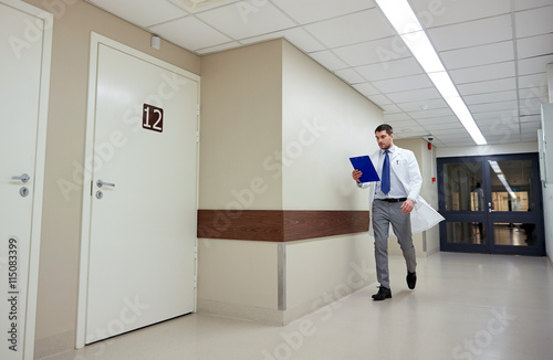 doctor with clipboard walking along hospital