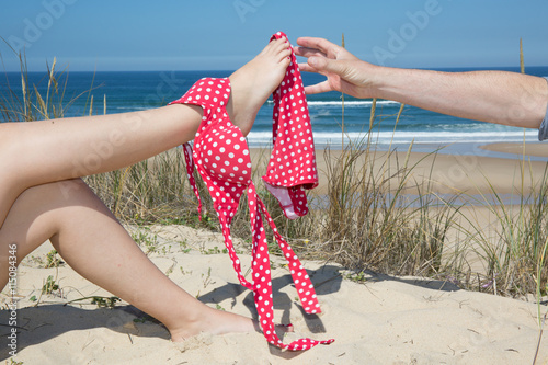 Woman with bikini on legs man try to catch on beach sea side