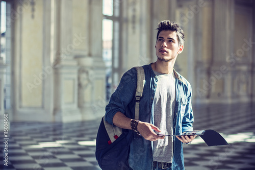 Handsome Man Holding a Guide Inside a Museum photo