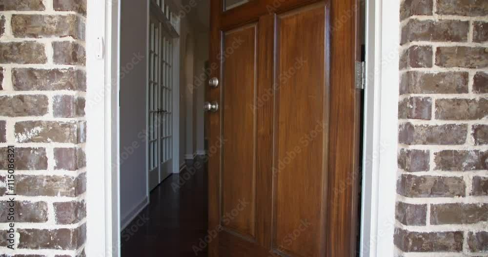 Front Home Entrance Door Open Rise Up. rising shot of the front entrance as the door opens to reveal the hallway of a modern residential home 
