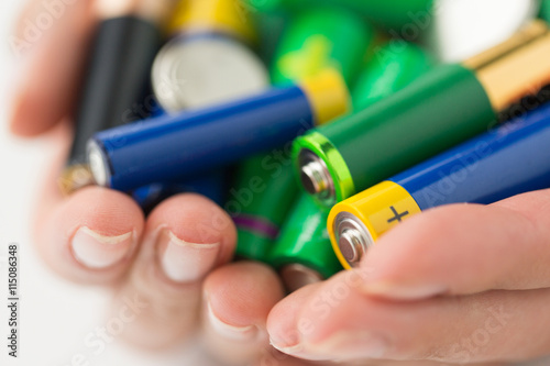 Foto close up of hands holding alkaline batteries heap