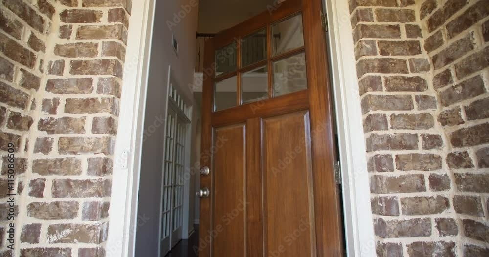 Front Home Entrance Low Angle Door Open Rise Up. rising low angle shot of the front entrance as the door opens to reveal the hallway of a modern residential home 
