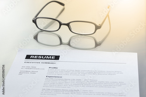 Resume information, pen, pencil and glasses. Warm tone