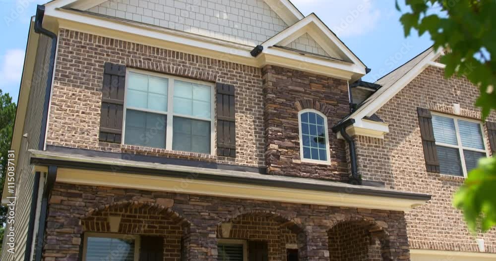 Brick Home Exterior Tilt Down Close Up. camera slowly lowers from the top of a modern residential new home build to the lower half of the home
